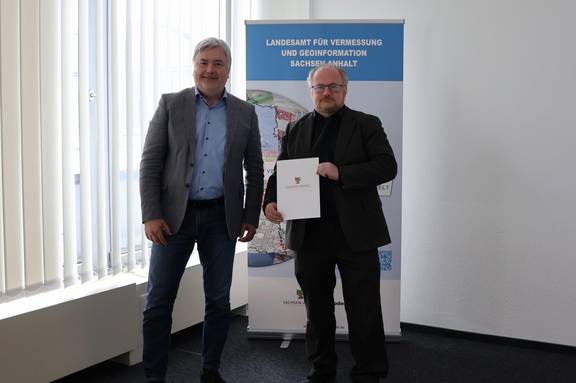 Herr Volker Galle (stellv. Behördenleiter) übergibt Herrn Dipl.-Ing. Bernhard Römmer die Bestallungsurkunde © LVermGeo ST Herr Volker Galle (stellv. Behördenleiter) übergibt Herrn Dipl.-Ing. Bernhard Römmer die Bestallungsurkunde